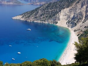A high angle view of the Myrtos Beach surrounded by the sea under the sunlight in Greece